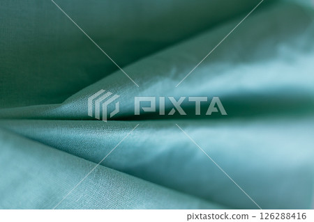 Close-up of green fabric emphasizing texture and folds 126288416