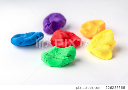 Colorful modeling clay pieces arranged on a white background Colorful modeling clay pieces arranged on a white background 126288566