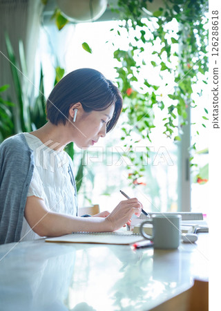 A woman studying with earphones A woman studying with earphones 126288618
