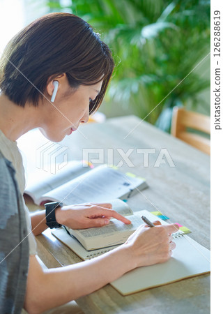 A woman studying with earphones A woman studying with earphones 126288619