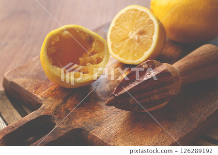 lemons and a wooden manual citrus juicer, on a chopping board, close-up, no people, lemons and a wooden manual citrus juicer, on a chopping board, close-up, no people, 126289192