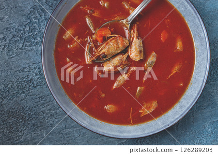 French shrimp bisque soup, in a plate, on a blue background, close-up, no people, French shrimp bisque soup, in a plate, on a blue background, close-up, no people, 126289203