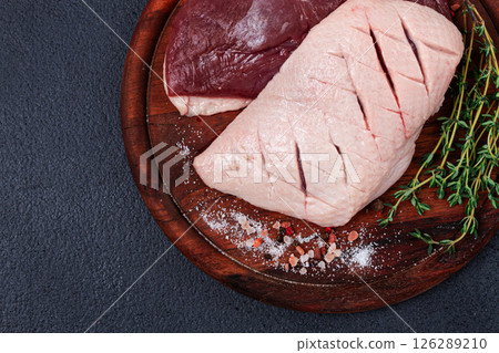 Fresh raw duck breasts, on a wooden chopping board, with herbs and spices, no people Fresh raw duck breasts, on a wooden chopping board, with herbs and spices, no people 126289210