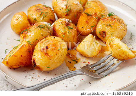 half-eaten fried new potatoes, with butter and dill, on a white plate, with a fork, at home, no people, half-eaten fried new potatoes, with butter and dill, on a white plate, with a fork, at home, no people, 126289216
