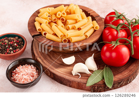 Pasta ingredients spread out, on a wooden surface, with tomatoes and spices, ready to cook, there are no people 126289246