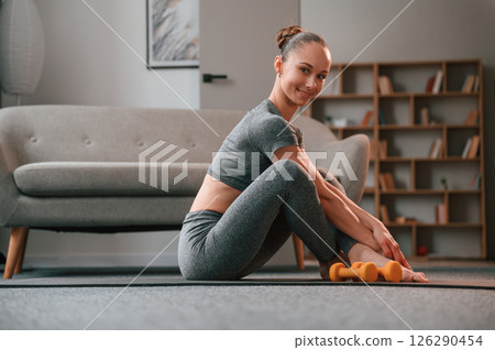 Relaxed, on the mat. Young woman in yoga clothes doing fitness indoors 126290454