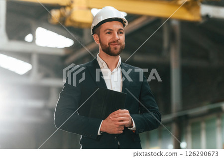 Portrait of manager that is in black formal wear at the factory 126290673