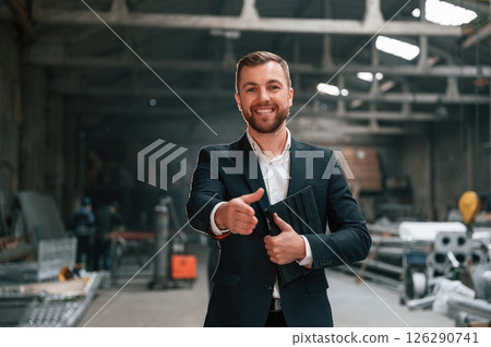 Friendly manager in black formal wear at the factory Friendly manager in black formal wear at the factory 126290741