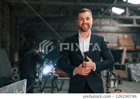 Portrait of manager that is in black formal wear at the factory Portrait of manager that is in black formal wear at the factory 126290746