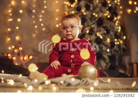 In glasses. Cute little baby is at home. New year decorations. Conception of holidays In glasses. Cute little baby is at home. New year decorations. Conception of holidays 126291082