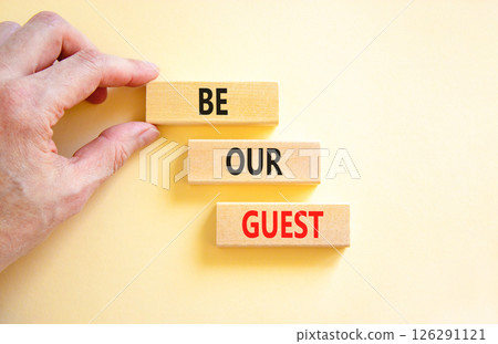 Be our guest symbol. Concept words Be our guest on beautiful wooden block. Businessman's hand. Beautiful white background. Business and be our guest concept. Copy space. Be our guest symbol. Concept words Be our guest on beautiful wooden block. Businessman's hand. Beautiful white background. Business and be our guest concept. Copy space. 126291121