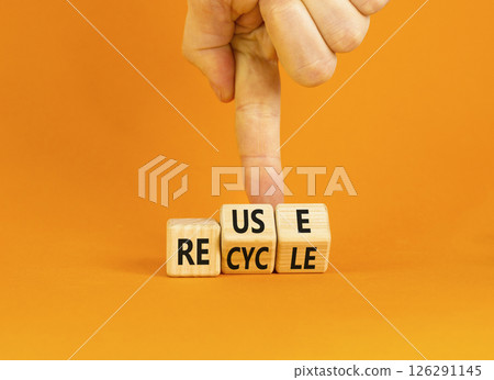 Reuse or recycle symbol. Concept words Reuse Recycle on wooden block. Beautiful orange table orange background. Businessman hand. Business reuse or recycle concept. Copy space. 126291145