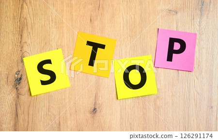 Stop symbol. Concept word Stop on beautiful colored paper. Beautiful wooden table wooden background. Business, lifestyle, support and stop concept. Copy space. Stop symbol. Concept word Stop on beautiful colored paper. Beautiful wooden table wooden background. Business, lifestyle, support and stop concept. Copy space. 126291174