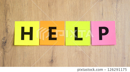 Help symbol. Concept word Help on beautiful colored paper. Beautiful wooden table wooden background. Business, lifestyle, support and help concept. Copy space. 126291175
