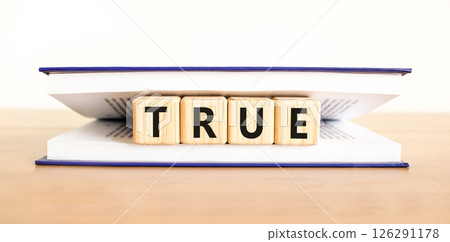 True symbol. Concept word True on beautiful wooden blocks in book. Beautiful wooden table white background. Business, lifestyle, support and true concept. Copy space. 126291178