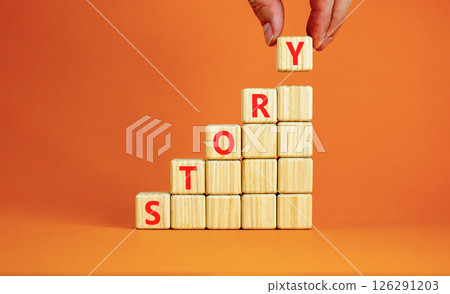 Story symbol. Concept word Story on beautiful wooden blocks. Beautiful orange table orange background. Businessman hand. Business lifestyle story concept. Copy space. Story symbol. Concept word Story on beautiful wooden blocks. Beautiful orange table orange background. Businessman hand. Business lifestyle story concept. Copy space. 126291203