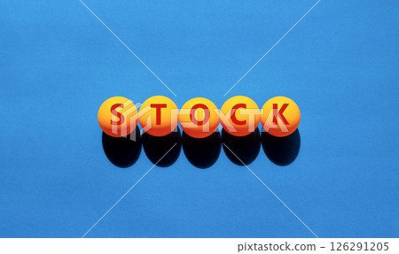 Stock symbol. Concept word Stock on beautiful yellow tennis ping pong balls. Beautiful wooden table wooden background. Business lifestyle stock concept. Copy space. 126291205