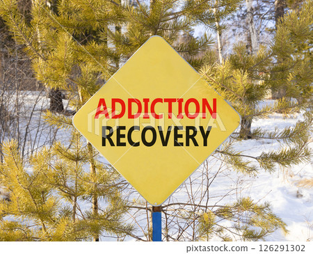 Addiction recovery symbol. Concept words Addiction recovery on beautiful yellow road sign. Beautiful winter forest background. Psychology addiction recovery concept. Copy space. Addiction recovery symbol. Concept words Addiction recovery on beautiful yellow road sign. Beautiful winter forest background. Psychology addiction recovery concept. Copy space. 126291302