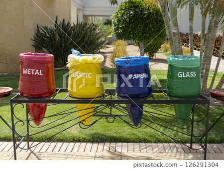 Color-coded recycle bins in Egypt hotel resort dedicated to separate waste collection for plastic glass metal and paper highlighting recycling and environmental responsibility. Environmental concept. 126291304