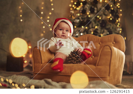 On the cute little sofa. Baby is at home. New year decorations. Conception of holidays On the cute little sofa. Baby is at home. New year decorations. Conception of holidays 126291415
