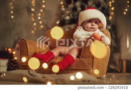On the cute little sofa. Baby is at home. New year decorations. Conception of holidays 126291418