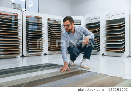 Sitting and choosing parquet. Man is in the store of goods for the home 126291992