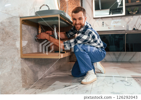Busy worker in blue uniform is in the bathroom Busy worker in blue uniform is in the bathroom 126292043