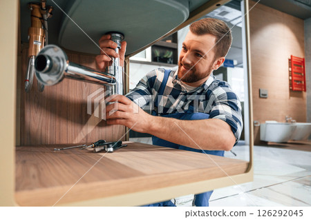 Busy worker in blue uniform is in the bathroom 126292045