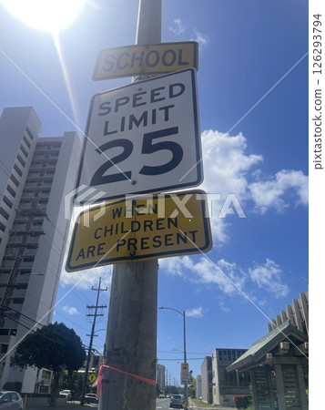 指示學校附近校區的限速標誌。保護兒童的安全。藍天和道路風景。 126293794