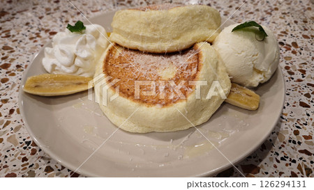 Delicious Japanese Fluffy Pancakes with Vanilla Ice Cream and Fresh Banana Slices on a Terrazzo Table 126294131