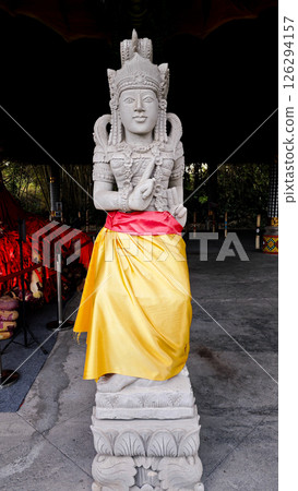 Sacred Balinese Hindu Stone Statue Draped in Yellow and Red Cloth in an Open Temple Setting Sacred Balinese Hindu Stone Statue Draped in Yellow and Red Cloth in an Open Temple Setting 126294157