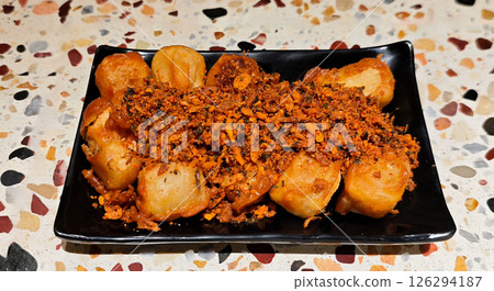 Crispy Fried Tofu Topped with Spicy Garlic Seasoning on a Black Plate Crispy Fried Tofu Topped with Spicy Garlic Seasoning on a Black Plate 126294187