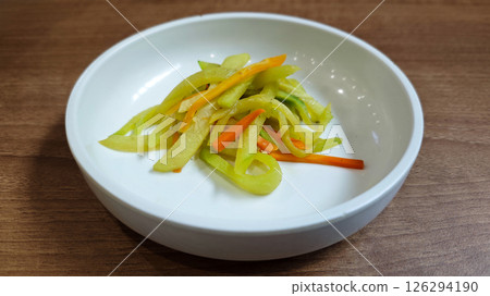 Close-up of Korean Stir-fried Zucchini and Carrot Banchan in White Ceramic Bowl on Wooden Surface 126294190