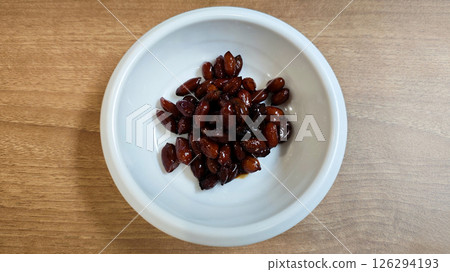 Close-up of Glossy Brown Candied Peanuts in a White Ceramic Bowl on a Light Wooden Table in a Restaurant Setting Close-up of Glossy Brown Candied Peanuts in a White Ceramic Bowl on a Light Wooden Table in a Restaurant Setting 126294193