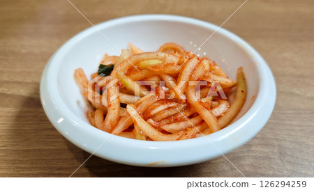 Close-Up of Korean Radish Banchan in a White Bowl on Wooden Table Background 126294259