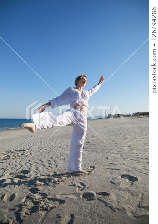 Blonde Girl With White Dress Dances On The Beach In Summer Near The Sea Blonde Girl With White Dress Dances On The Beach In Summer Near The Sea 126294286