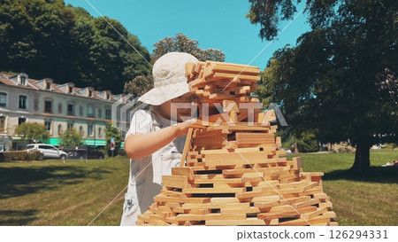 A smart little girl builds the big tower with toy wooden bricks A smart little girl builds the big tower with toy wooden bricks 126294331