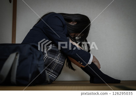 High school girl sitting cross-legged in a Japanese-style room: Bullying, school refusal, social withdrawal, anxiety about the future High school girl sitting cross-legged in a Japanese-style room: Bullying, school refusal, social withdrawal, anxiety about the future 126295035