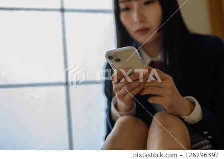 High school girl looking at smartphone in Japanese-style room, bullying, school refusal, SNS trouble, natural color High school girl looking at smartphone in Japanese-style room, bullying, school refusal, SNS trouble, natural color 126296392