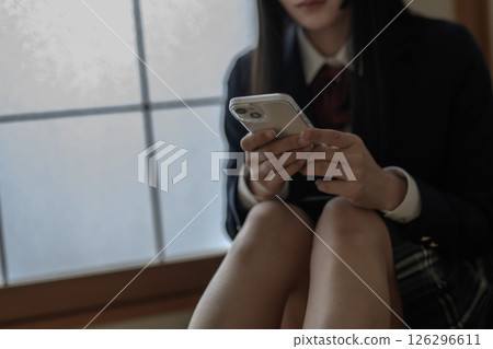 High school girl looking at smartphone in Japanese-style room, bullying, school refusal, SNS trouble 126296611