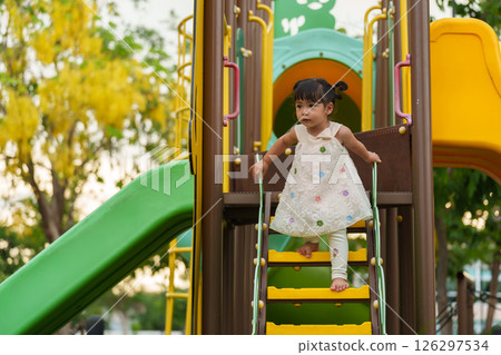 happy toddler girl playing at a outdoor playground in park 126297534