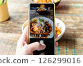 POV shot of taking photo of a meal using the camera app of a smartphone 126299016