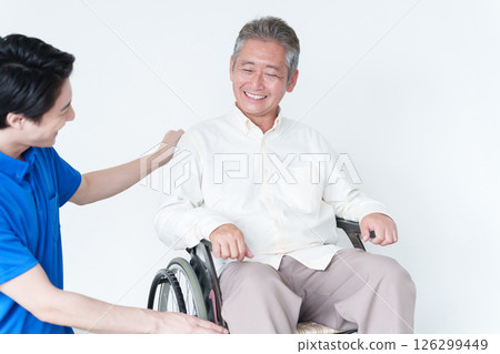 Male caregiver and elderly man in a wheelchair Male caregiver and elderly man in a wheelchair 126299449