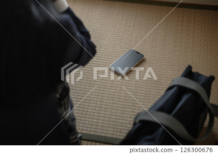 High school girl looking at smartphone placed on tatami mat in Japanese-style room Bullying, school refusal, SNS troubles, trimming High school girl looking at smartphone placed on tatami mat in Japanese-style room Bullying, school refusal, SNS troubles, trimming 126300676