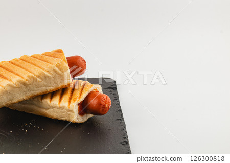 Delicious hot dogs served in crispy bread rolls on a platter Delicious hot dogs served in crispy bread rolls on a platter 126300818