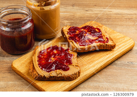 Delicious peanut butter and jelly sandwiches on wooden board 126300979