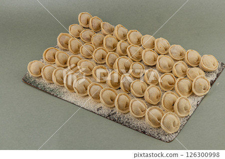 Homemade dumplings lined up on a floured surface ready to cook Homemade dumplings lined up on a floured surface ready to cook 126300998