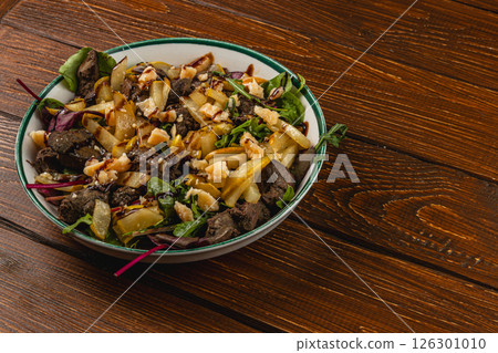 Healthy salad with greens, beef, and apples on a wooden table Healthy salad with greens, beef, and apples on a wooden table 126301010