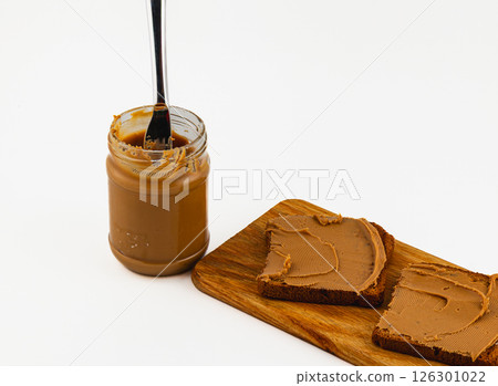 Creamy spread on bread with a fork and jar nearby 126301022