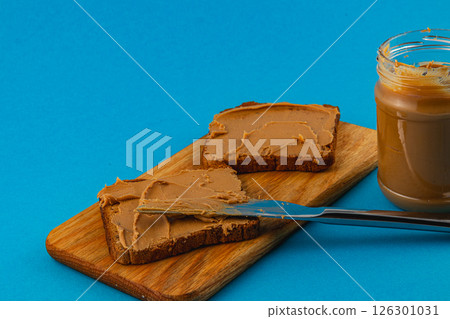 Slices of bread topped with creamy spread on a wooden board 126301031